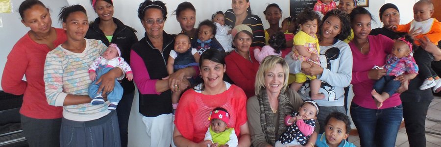 Die groot groep mammas met hul babas, met die beoordelaars, Rochelle de Villiers en Antoinette Louw voor - elk met ‘n baba op die skoot